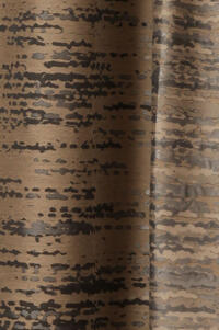 Overgordijn in bruingrijze nonchalant hangende basisstof. Met ingeweven patroon van "vlekken" in grijs en zwart/bruin.