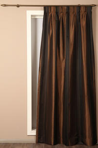 Glanzende taft met bruine en zwarte lengtestreep. Door het streeppatroon loopt een golvend patroon in zwarte breedte strepen