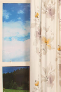 Soepel vallende fijn geweven gordijnstof met een kleurig aquarel bloemmotief