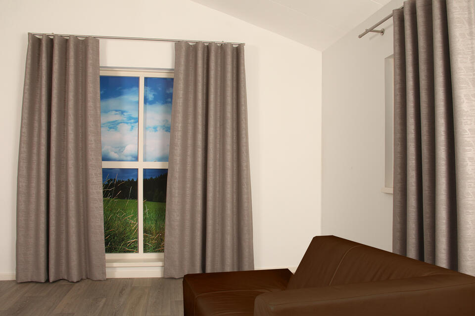 Deze semi-verduisterende gordijnstof heeft een ingeperst grafisch dessin op een gemêleerd gronddoek